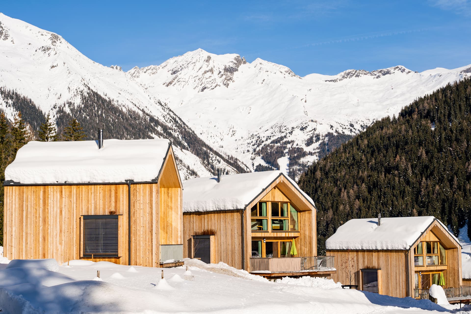 Winterliche Chalets mit Schneekappen vor dem Bergpanorama