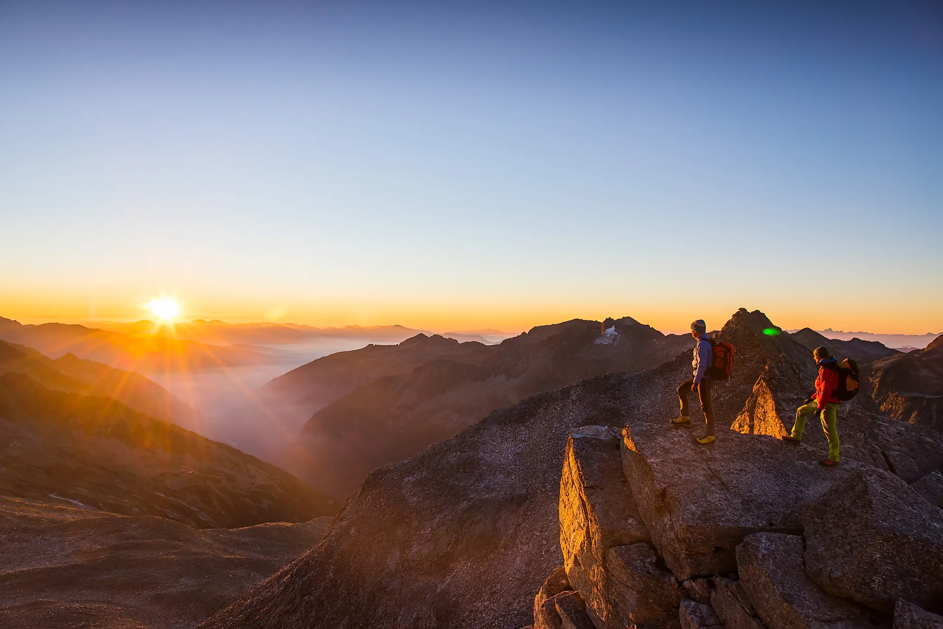 Wanderer am Grat beim Sonnenaufgang