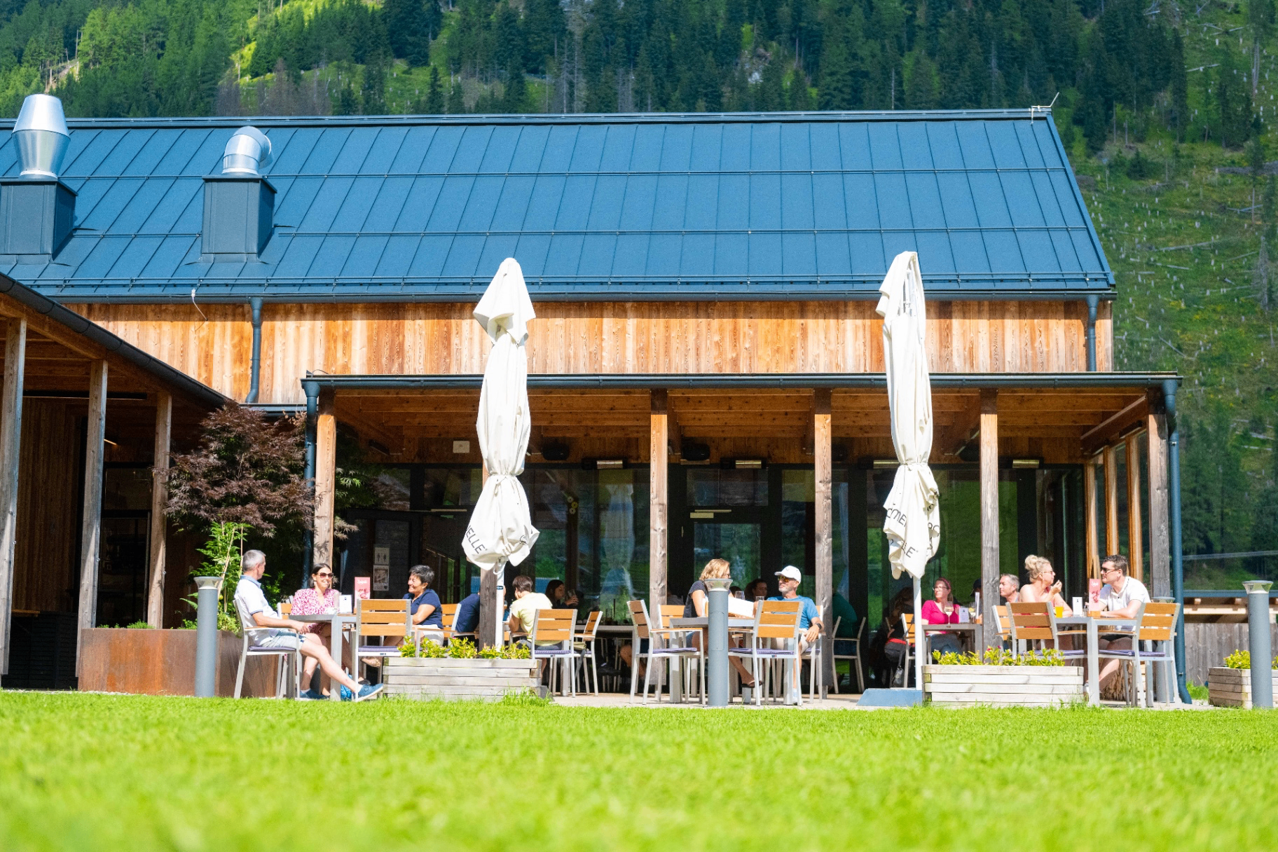 Restaurant HOCHoben mit langem Holztisch und Bergblick